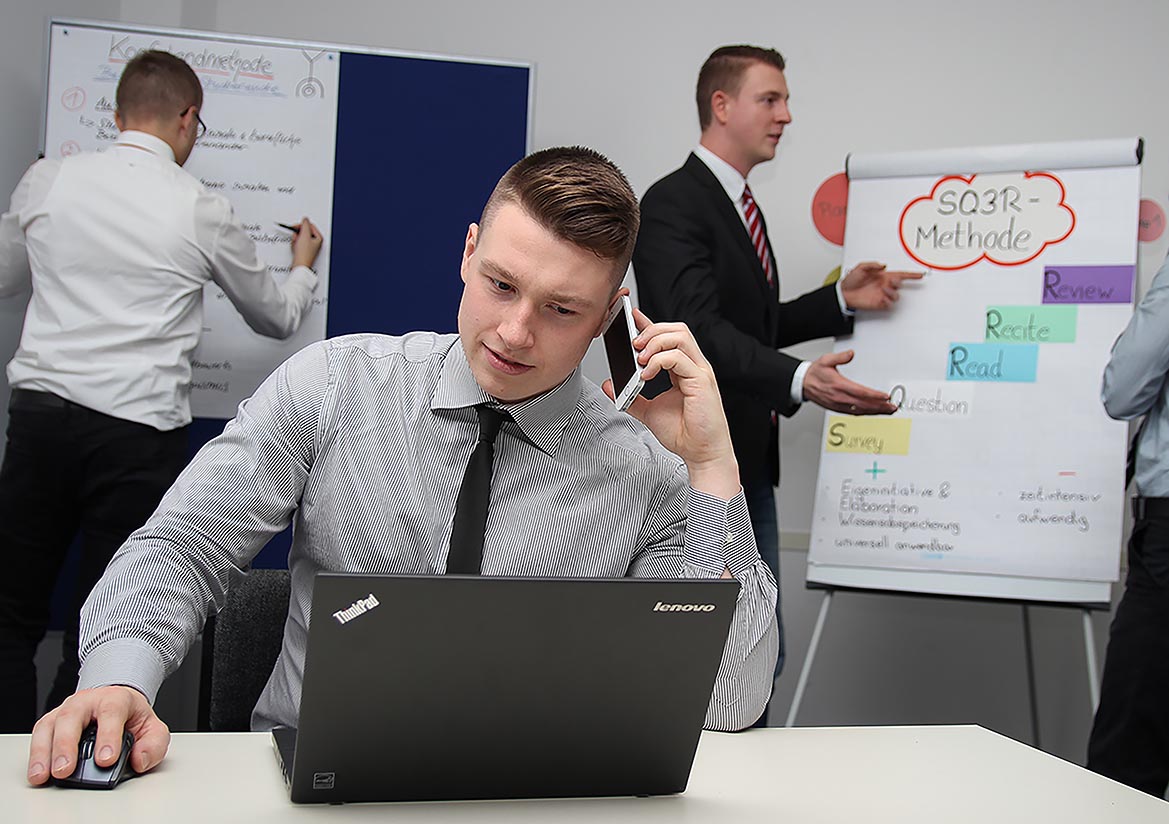 This is an image of a student on laptop, talking on a cell phone.